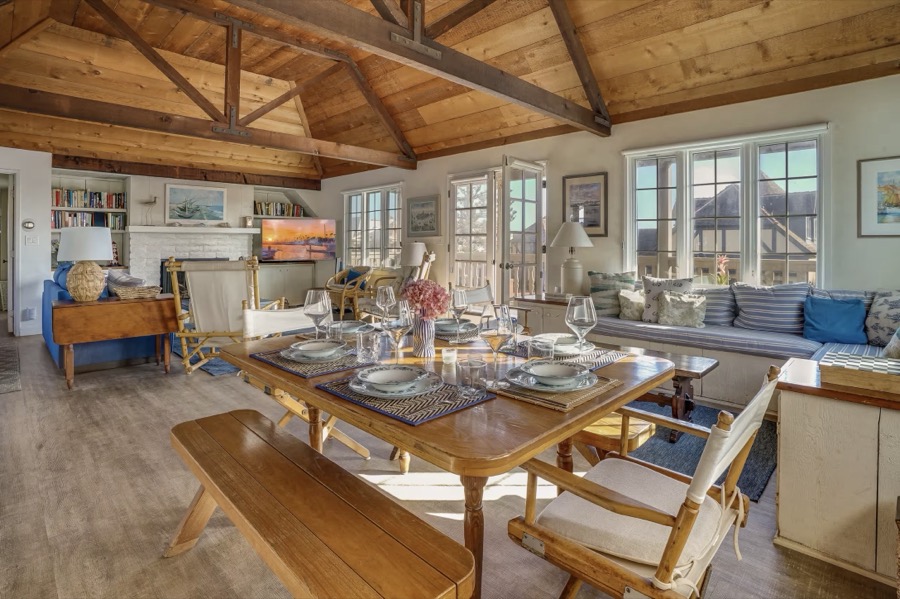 The dining table laid under vaulted beams, afternoon light across the room