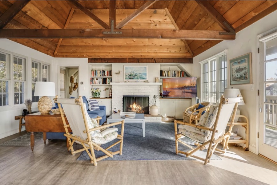 The great room under vaulted ceilings with the fireplace lit