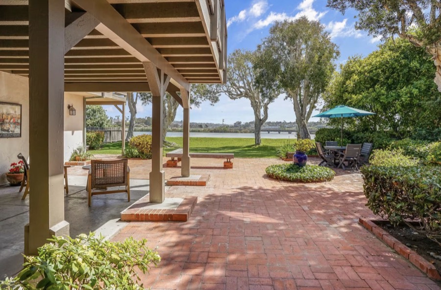 The covered brick patio looking across the lawn to the lagoon