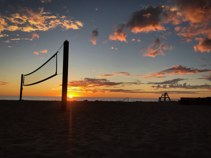Sand volleyball net on the beach at sunset