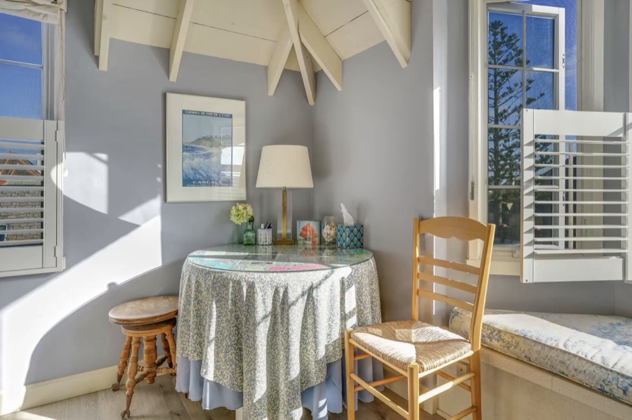 A writing table and chair in a quiet corner, shutters half open